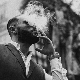 A man who smokes a cigarette.